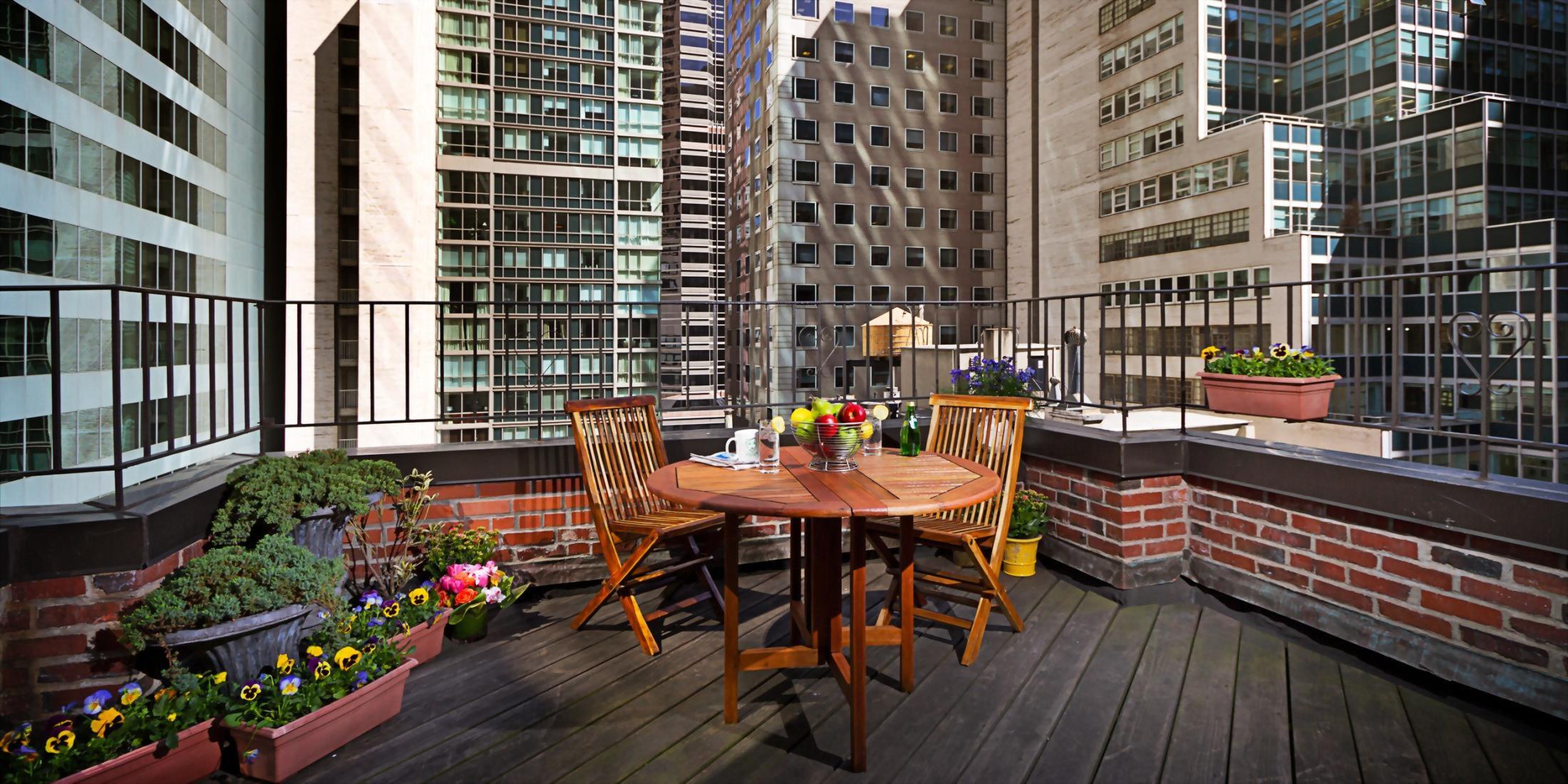 outdoor terrace with table overlooking the streets of manhattan