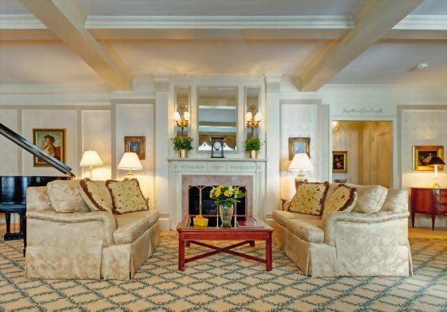 Living room of the Presidential Suite honoring Vladimir Horowitz with faux fireplace, Vladimir Horowitz's own piano, a kitchen, dining table and an outdoor terrace.