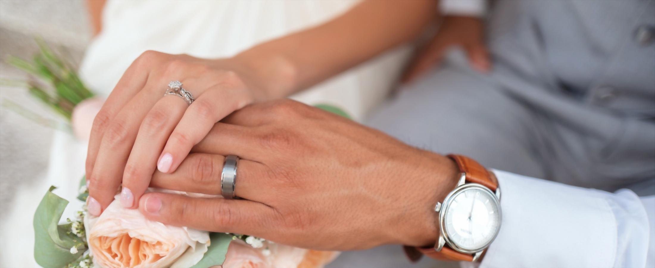 Zoomed photo of wedding bands on a floral arrangement.