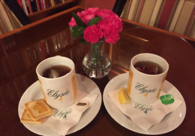 Hotel Elysee Mugs filled with tea and accompanied with cookies.